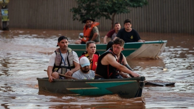 Mitglieder eines Rettungsteams bei der Evakuierung von Menschen, die von einer Überschwemmung betroffen sind. (Foto: Claudia Martini/XinHua/dpa)