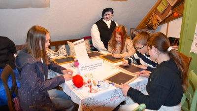 Bei der Ausstellungseröffnung probierten Kinder im Vogteimuseum gleich das Schreiben auf Schiefertafeln mit einem Griffel aus. Bei manchen quietschte es, was für Erheiterung sorgte. (Foto: Werner Wenk)