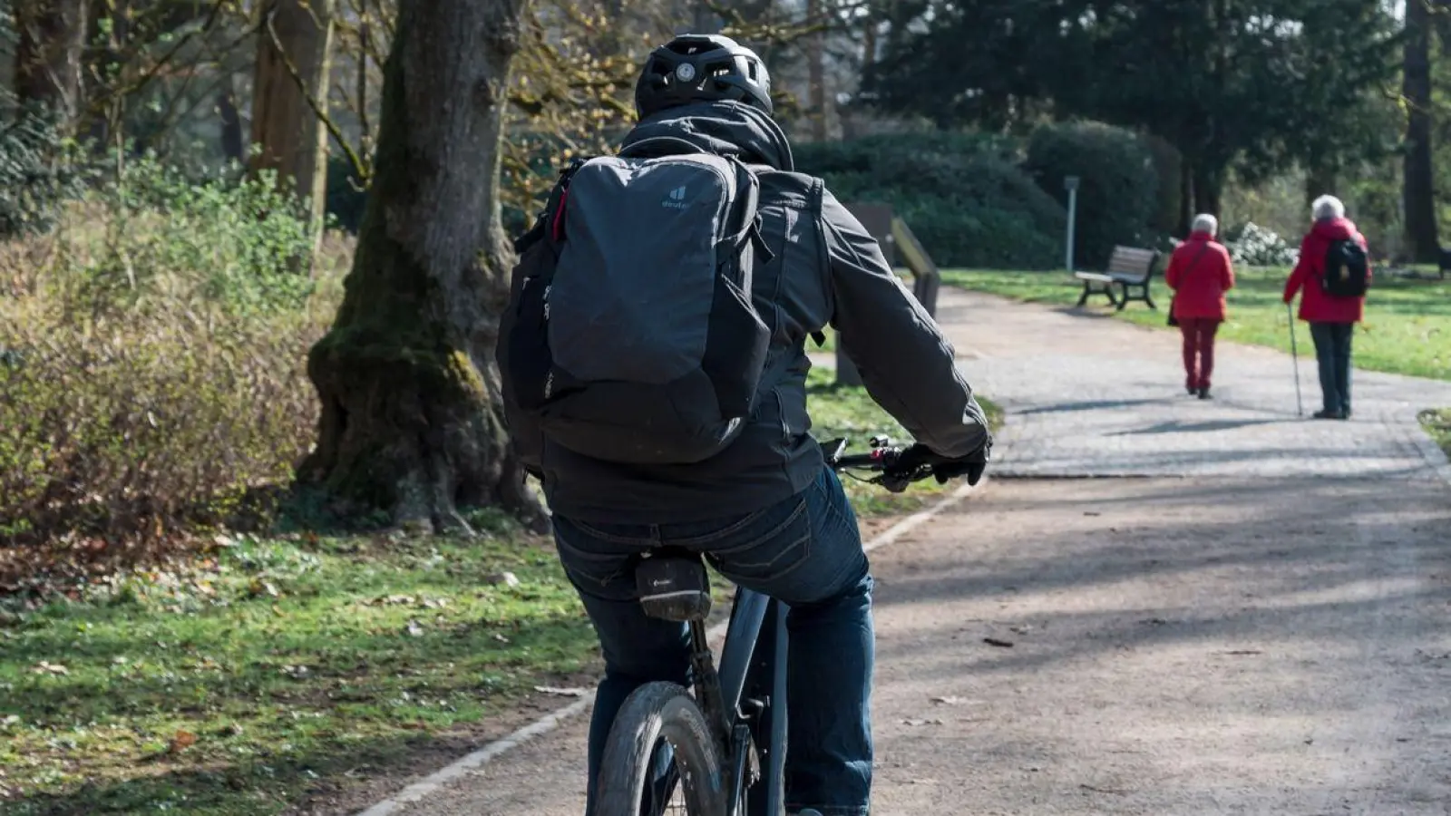 Eine Person fährt mit dem Fahrrad durch den Hofgarten. (Foto: Daniel Vogl/dpa)