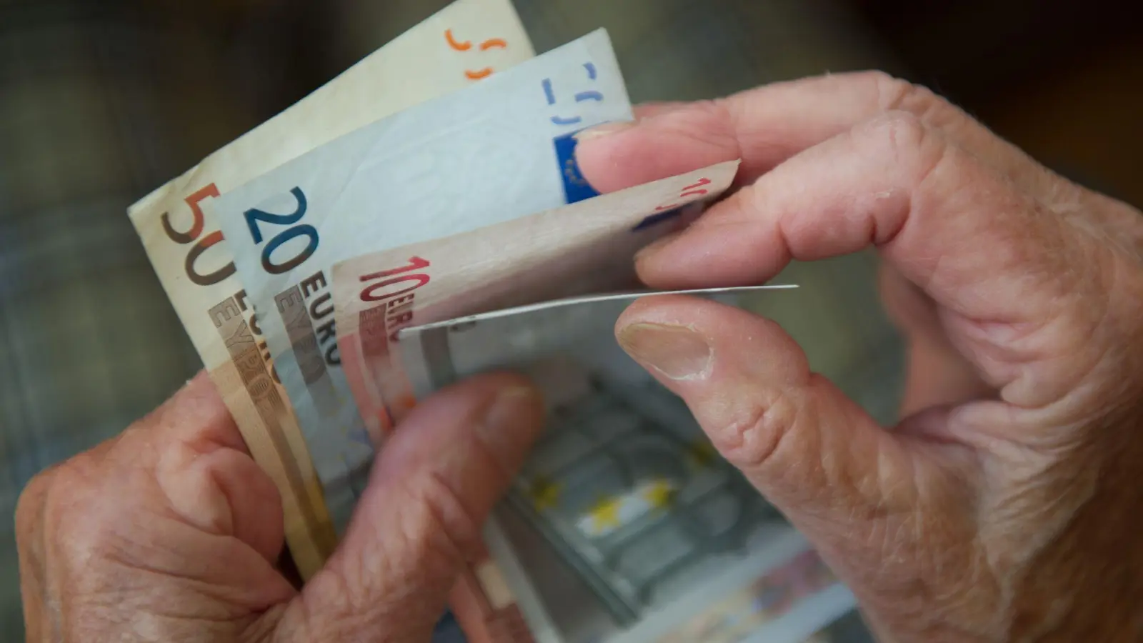 Eine ältere Frau zählt Geld. (Archivbild) (Foto: Marijan Murat/dpa)