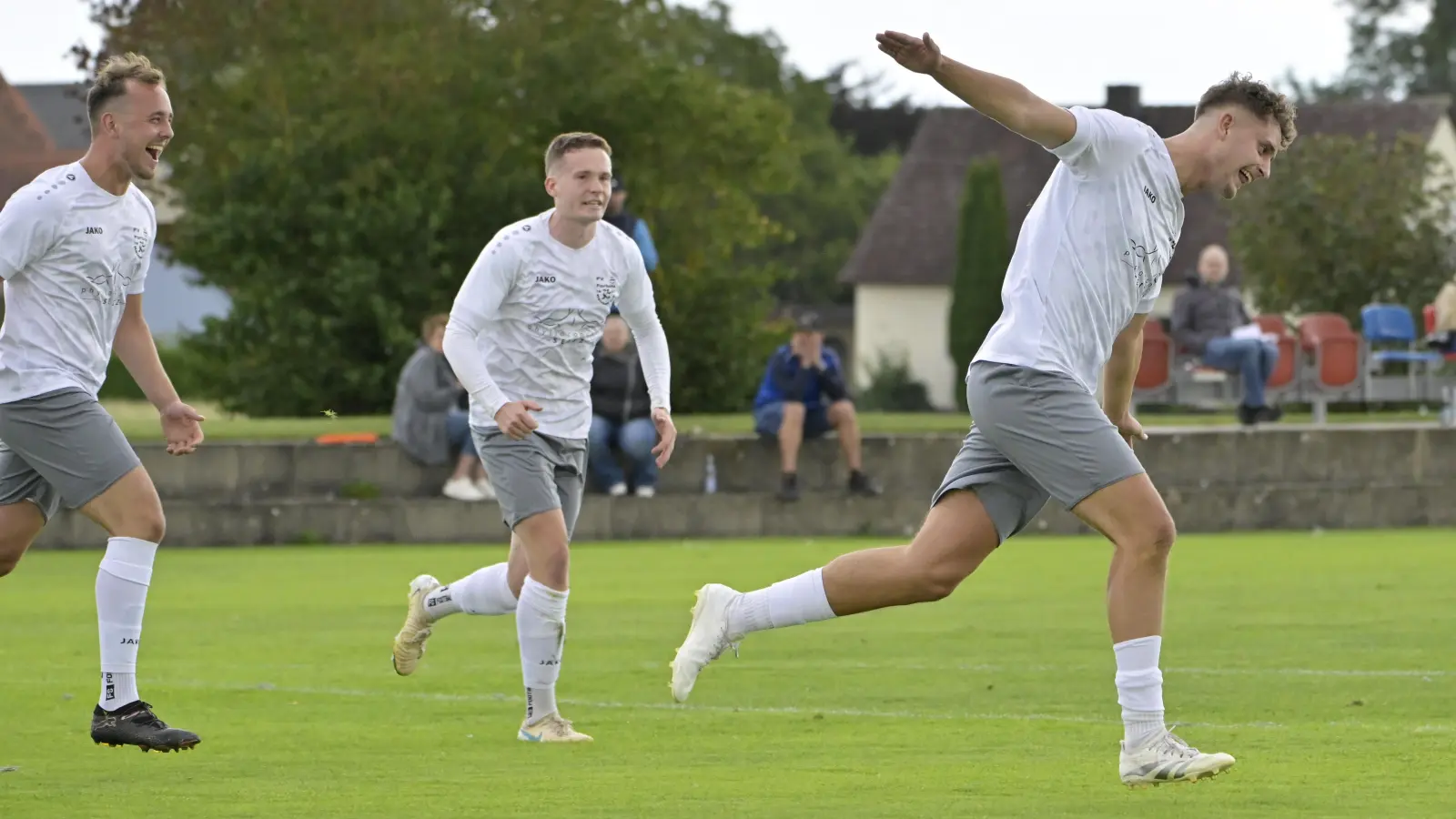 Überflieger Jan Zimmermann (rechts) jubelt hier über sein drittes von vier Toren beim 5:1-Erfolg von Fortuna Neuses gegen den SV Alesheim. Luis Meyer (links) und Kevin Muhr wollen den Torschützen einfangen. (Foto: Martin Rügner)