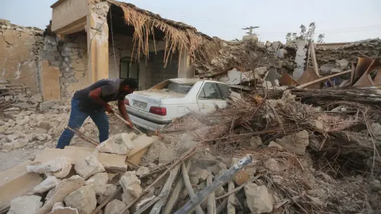 Ein Mann räumt die Trümmer nach einem Erdbeben im Dorf Sayeh Khosh im Südiran auf. (Foto: Abdolhossein Rezvani/AP/dpa)