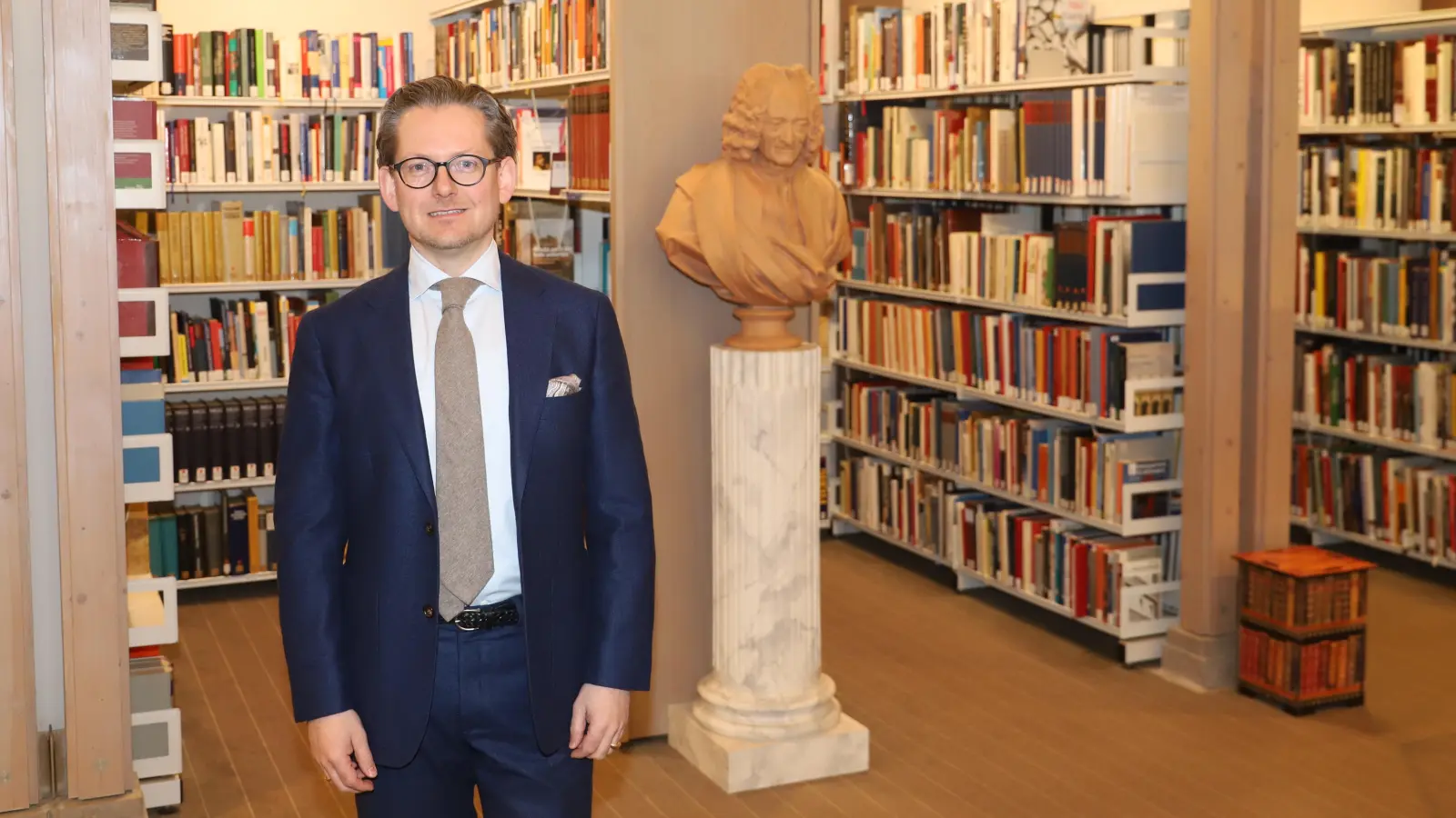 Christian Mantsch, Leiter der Staatlichen Bibliothek, recherchierte hier schon als Schüler. Die Einrichtung heißt auch Schlossbibliothek. Davon zeugt eine Voltaire-Büste, einst ein markgräfliches Geschenk. (Foto: Oliver Herbst)