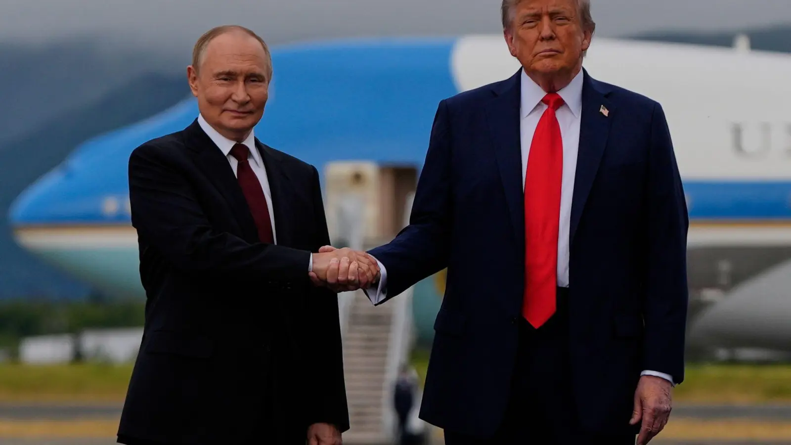 US-Präsident Donald Trump (r) und der russische Präsident Wladimir Putin geben sich auf dem Militärstützpunkt Joint Base Elmendorf-Richardson (in Alaska) die Hand. (Foto: Julia Demaree Nikhinson/AP/dpa)