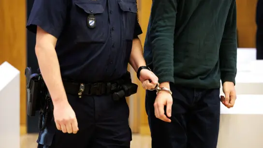 Einer von zwei wegen Mordes angeklagten Männern wird in den Hochsicherheitsgerichtssaal geführt. (Foto: Matthias Balk/dpa)