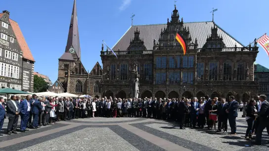 Bundespräsident Steinmeier steht im Sommer 2018 mit Mitgliedern des Diplomatischen Korps für ein Gruppenfoto auf dem Rathausplatz in Bremen. (Foto: Carmen Jaspersen/dpa/Bildarchiv)