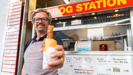 „H-Blockx“-Sänger Henning Wehland hilft am Hot Dog-Stand in Münster aus. Der in der Studentenstadt beliebte Imbiss hat nach eigenen Angaben große Probleme, Personal zu finden. (Foto: Guido Kirchner/dpa)