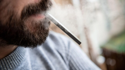 Ein Mann hält eine E-Zigarette im Mund. Wegen anstehender Steuererhöhungen ziehen Hersteller und Händler von E-Zigaretten vor das Bundesverfassungsgericht. (Foto: Fabian Strauch/dpa)
