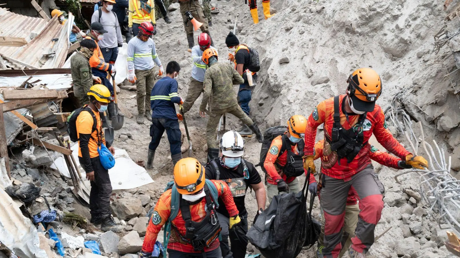 Rettungskräfte tragen ein Opfer aus dem von einem Erdrutsch betroffenen Dorf Masara. (Foto: Uncredited/AP/dpa)