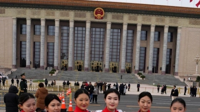 Hostessen posieren vor einer Sitzung des Chinesischen Nationalen Volkskongresses (NVK) vor der Großen Halle des Volkes. (Foto: Ng Han Guan/AP/dpa)