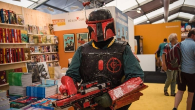 Ein als der Star Wars Charakter „Boba Fett“ verkleidete Cosplayer geht durch den Comic Salon. (Foto: Nicolas Armer/dpa/Archivbild)