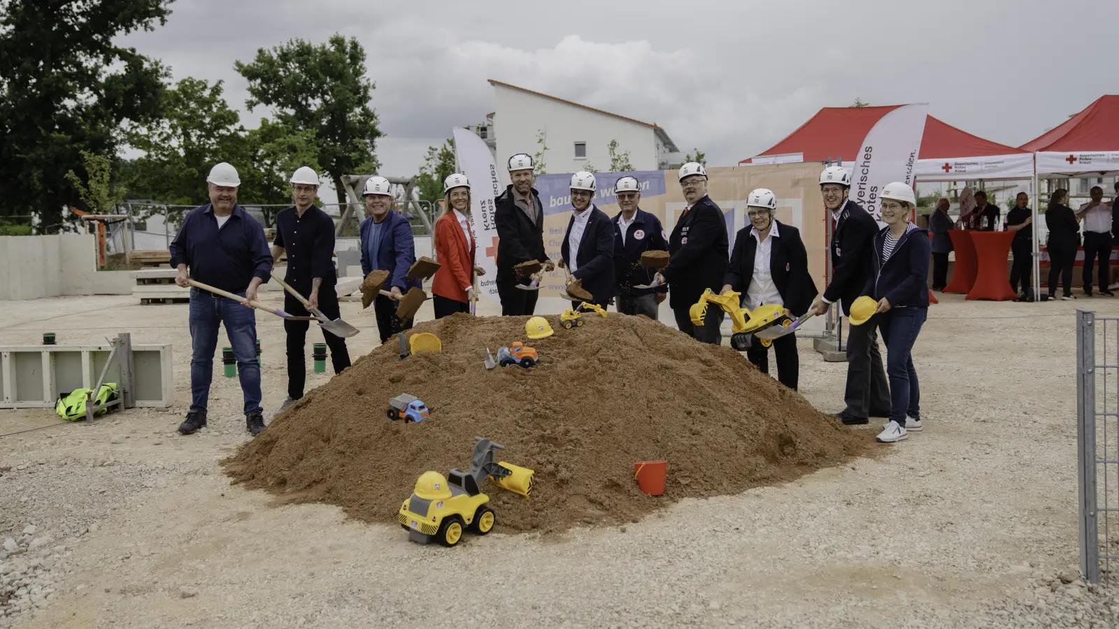 Spatenstich für die Kita-Erweiterung (von links): Heinz Scheuenstuhl vom gleichnamigen Ingenieursbüro, Projektleiter Simon Paulus, Bürgermeister Gerhard Rammler, Theresa Magerl vom BRK, Oliver Lang (Firma Beil), BRK-Geschäftsführer Christian Bernhard, Bezirksvorsitzender Harald Pruckner, Schatzmeister Dieter Schinnagel, Vorsitzende Anna-Maria Wöhl, ihr Stellvertreter Jörg Edelmann und Karin Eichner (Firma Beil). (Foto: Florian Eichinger)