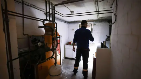 Ein Mitarbeiter eines Diesel- und Heizöl-Unternehmens prüft die Kunststofftanks in einem Heizungskeller bei der Heizöllieferung. Jede dritte Ölheizung in Deutschland weist Mängel auf. (Foto: Christian Charisius/dpa)