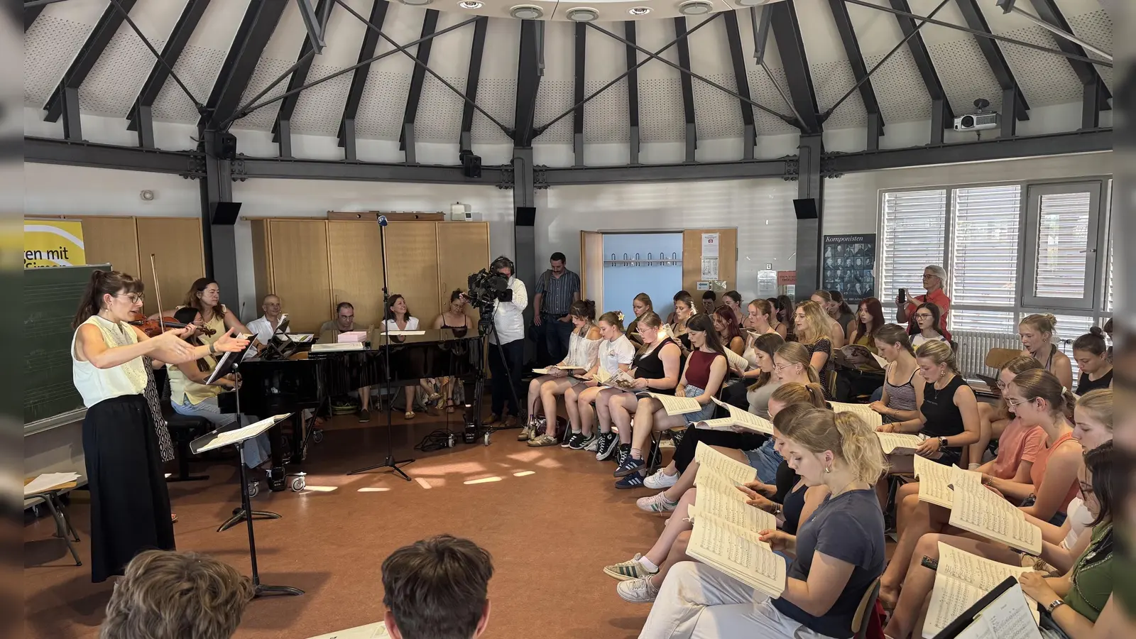 Singen in der Hitze des Musiksaales: Der Kammerchor des Gymnasium Carolinum probte mit Mitgliedern des Chores und Orchesters des Bayerischen Rundfunks für zwei große Konzerte im Juli.  (Foto: Lara Hausleitner)