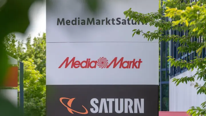 Ein Schild mit den Logos von Media Markt und Saturn: Das Geschäft in Deutschland stagnierte. (Foto: Armin Weigel/dpa)