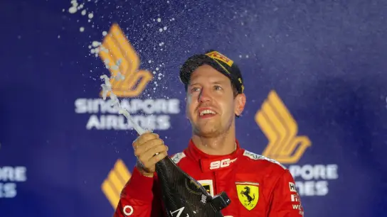 Ferrari-Pilot Sebastian Vettel lässt nach seinem Sieg 2019 in Singapur die Champagnerkorken knallen. (Foto: Vincent Thian/AP/dpa/Archivbild)