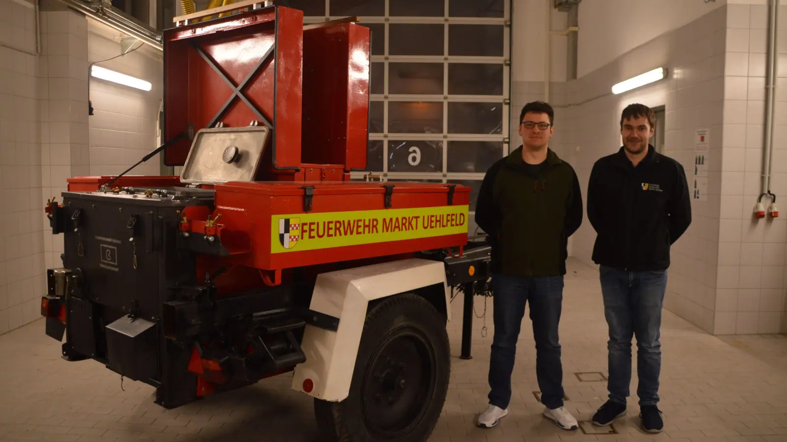Stolz präsentieren Kümmerer Christian Wio (links) und der Uehlfelder Feuerwehrkommandant Tobias Baum ihre sanierte Feldküche. Sie stammt von der Nationalen Volksarmee der DDR. (Foto: Johannes Zimmermann)
