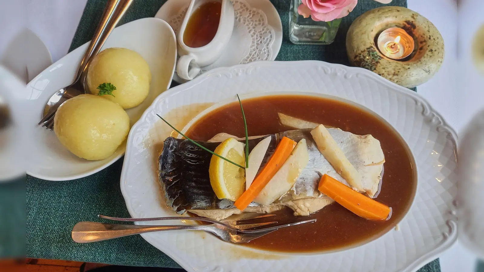 Thüringer Klöße werden im Resort Schloss Auerstedt zum Karpfen mit Bratensoße serviert.  (Foto: Andreas Drouve/dpa-tmn)