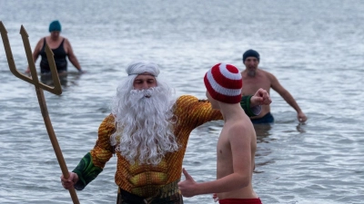 Als Neptun verkleidet steigt Tim Bergelt zusammen mit anderen Hobbyschwimmern aus dem 5 Grad kalten Meer, hier die Ostsee. (Foto: Stephan Schulz/dpa)