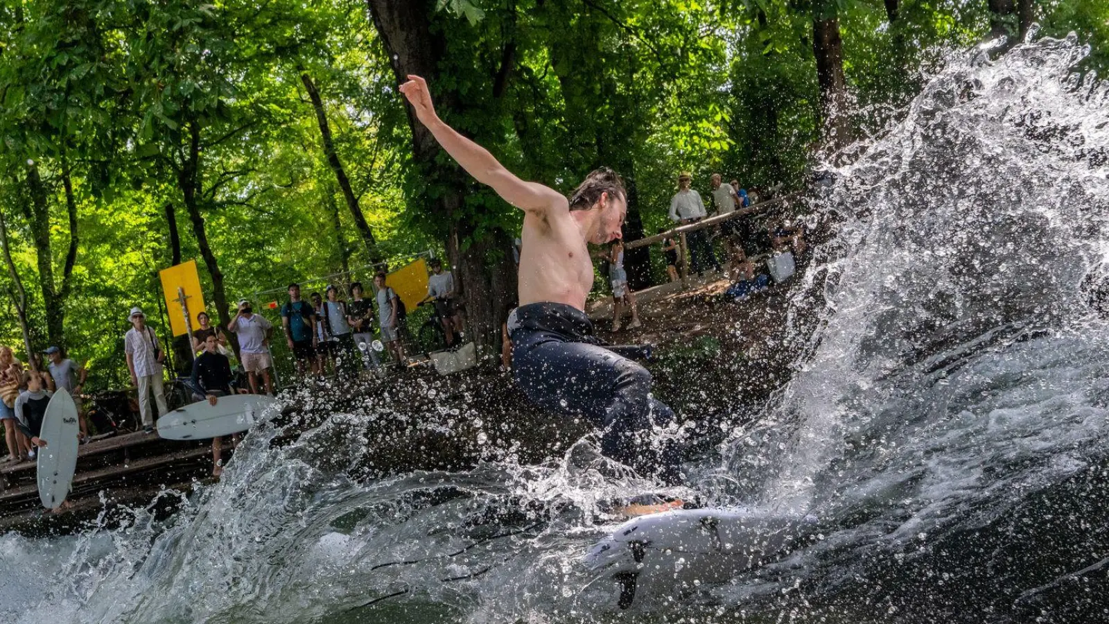 Ab in die erfrischenden Fluten - bei dieser Hitze genießen die Surferinnen und Surfer eine Abkühlung an der Eisbachwelle im Englischen Garten.  (Foto: Peter Kneffel/dpa)
