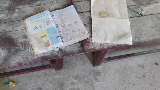 Ein Schulbuch und ein Notizheft liegen staubbedeckt in den Überresten der angegriffenen Schule in der Region Sagaing. (Foto: Uncredited/AP/dpa)