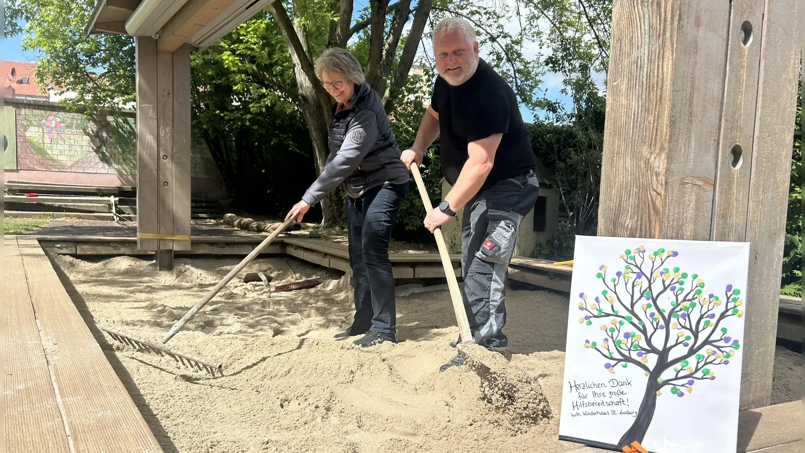 Acht Tonnen Sand wollen verteilt sein: Unternehmer Jürgen Wolf und Kiga-Leiterin Andrea Lang packten selbst mit Rechen und Schaufel an. (Foto: Florian Pöhlmann)