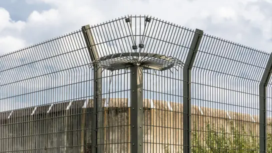 Eine Mauer und ein Drahtzaun eines Gefängnisses. (Foto: Markus Scholz/dpa/Symbolbild)