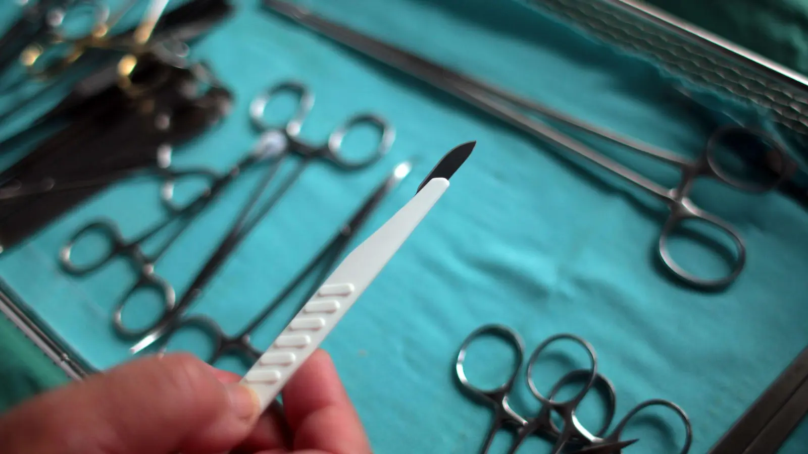 Der Chirurg hält im OP ein Skalpell in der Hand. (Archivbild) (Foto: picture alliance / dpa)