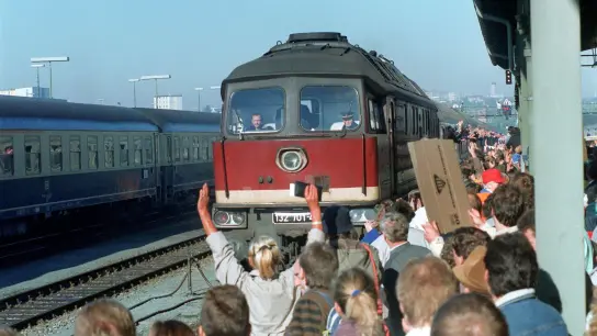 Von jubelnden Menschenmassen werden im Jahr 1989 Menschen aus der DDR am auf dem Bahnhof im bayerischen Hof empfangen (Foto: Wolfgang Eilmes/dpa/Archivbild)