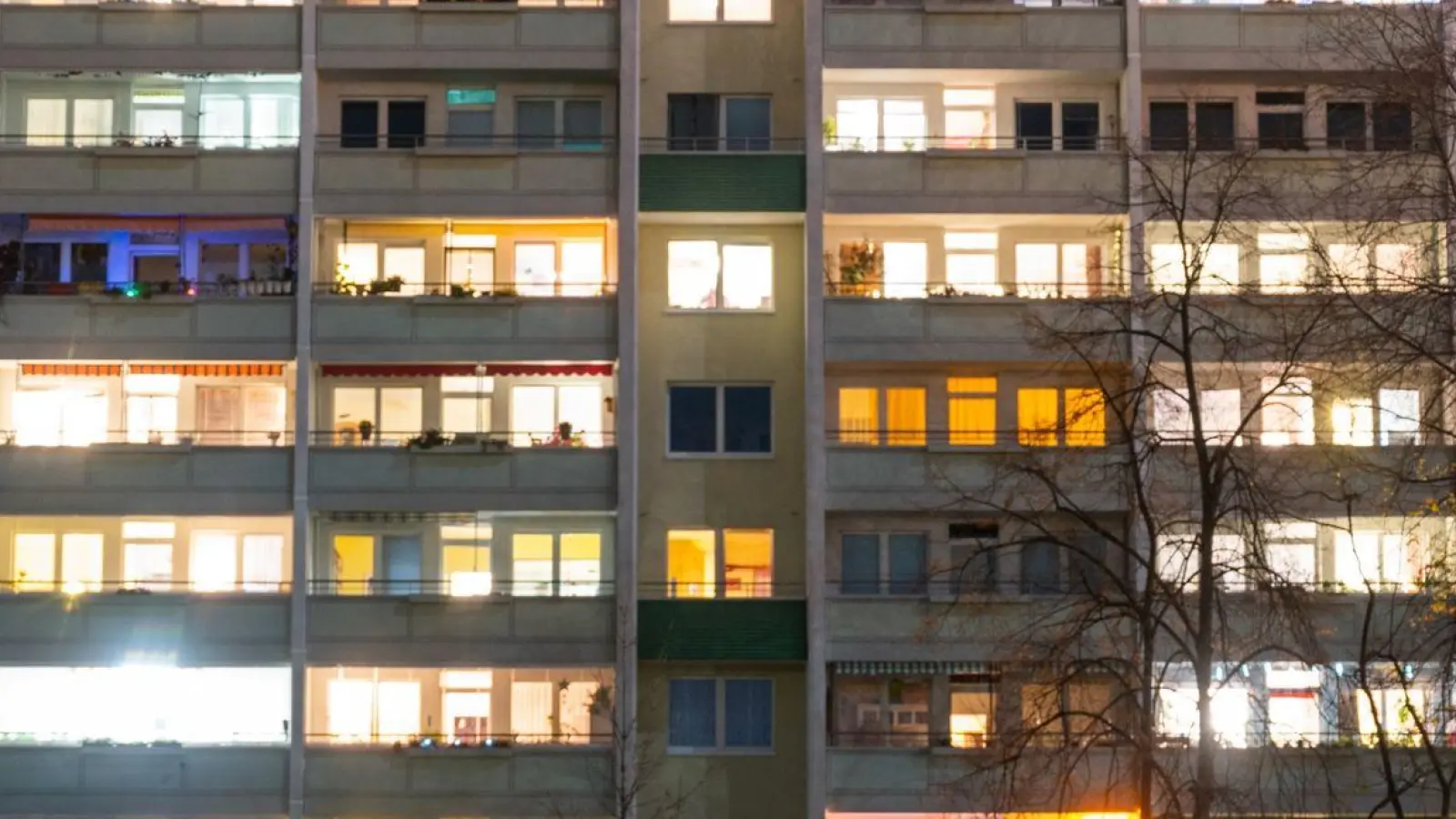 In einem Hochhaus sind einige Fenster beleuchtet. (Foto: Christophe Gateau/dpa)