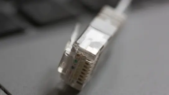 Ein LAN-Kabel liegt auf einem Computerlaptop: Rechtsanspruch auf Versorgung mit Telefon und schnellem Internetzugang. (Foto: Fernando Gutierrez-Juarez/dpa-Zentralbild/dpa)