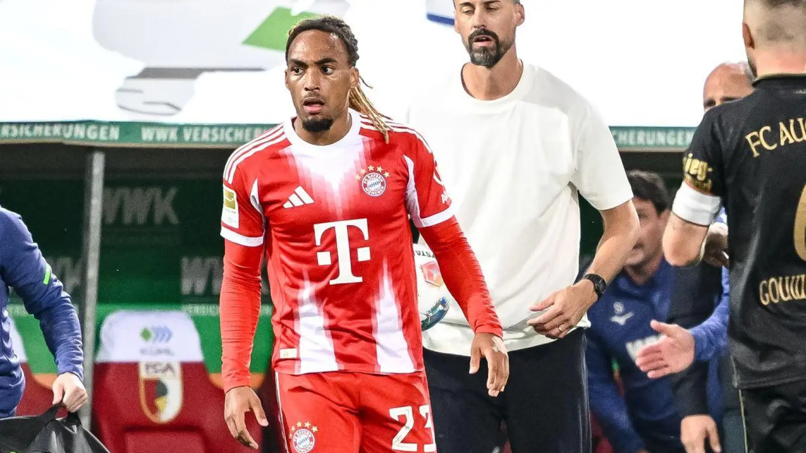 Bayern-Profi Sacha Boey (M.) sah für sein Foul an Augsburgs Robin Fellhauer Gelb. (Foto: Harry Langer/dpa)