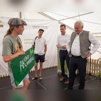 Eine spontane Aktion am Johannitag: Ein Student des Arbeitskreises Ökolandbau konfrontierte den Bundeslandwirtschaftsminister Alois Rainer (rechts) auf der Bühne mit Fragen zur ökologischen Landwirtschaft. (Foto: Mirko Fryska)