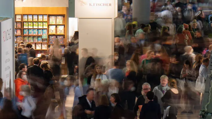 Besucher gehen während der Frankfurter Buchmesse durch einen Gang. (Foto: Sebastian Gollnow/dpa)