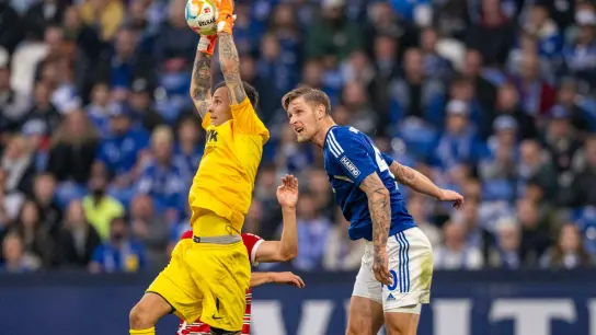Augsburgs Torwart Rafal Gikiewicz (l) und Schalkes Sebastian Polter kämpfen um den Ball. (Foto: David Inderlied/dpa)