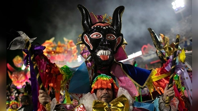 Ein Darsteller der Sambaschule Beija Flor zieht während der Karnevalsfeierlichkeiten im Sambadrom durch die Straßen. (Foto: Bruna Prado/AP/dpa)