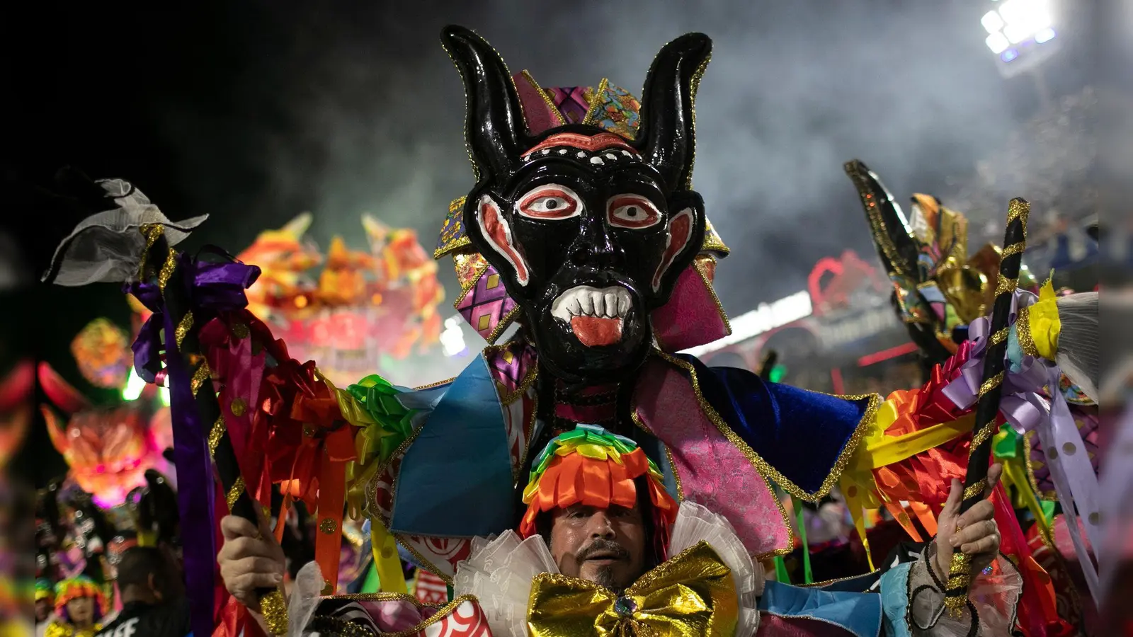 Ein Darsteller der Sambaschule Beija Flor zieht während der Karnevalsfeierlichkeiten im Sambadrom durch die Straßen. (Foto: Bruna Prado/AP/dpa)