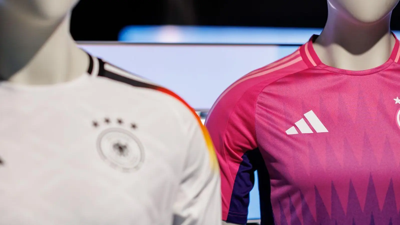 Wurde kontrovers diskutiert: die Farbwahl des neuen Pink und lilafarbenen Auswärtstrikots der deutschen Fußballnationalmannschaft (r). (Foto: Daniel Karmann/dpa)