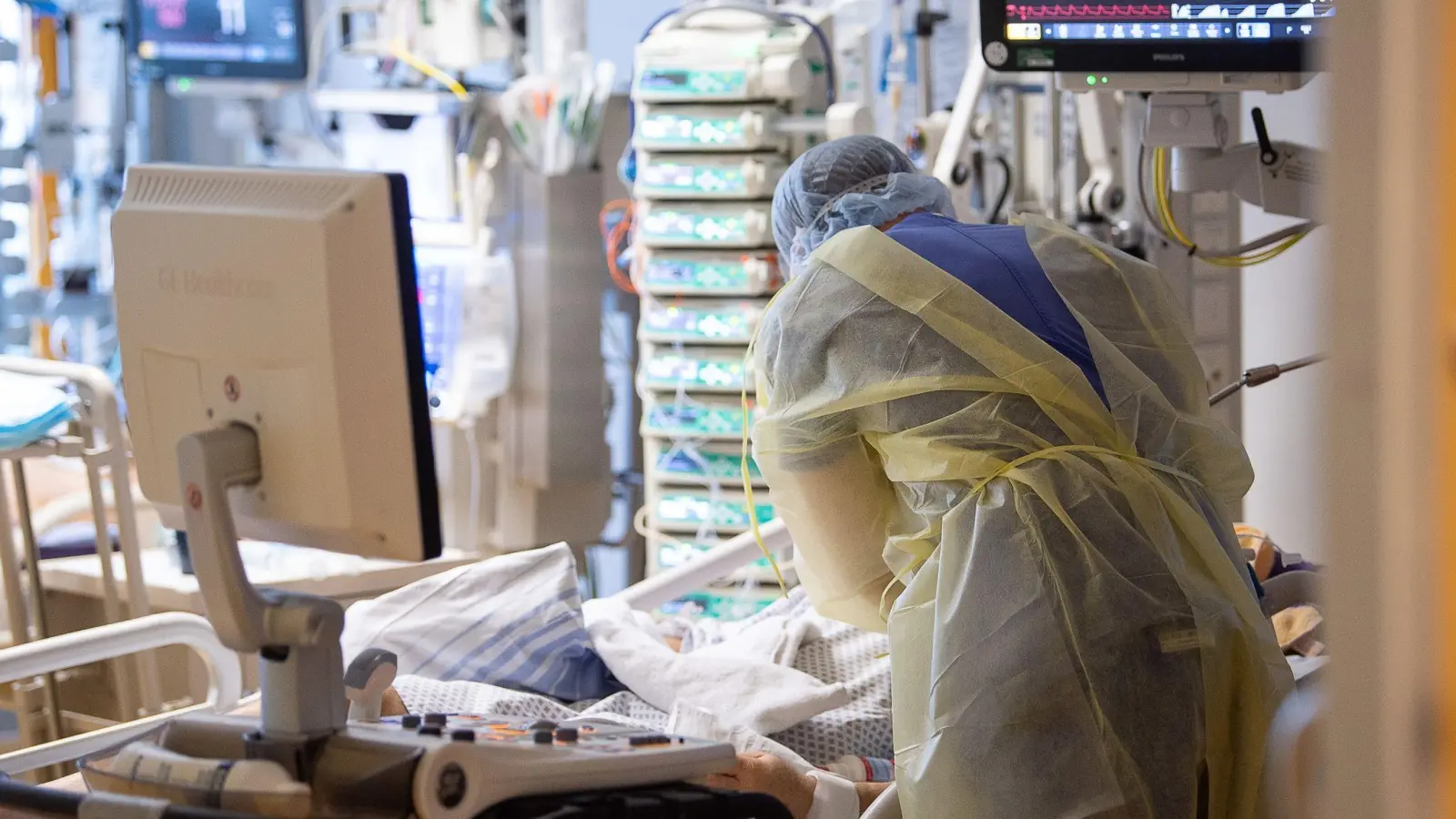Ein Intensivpfleger steht auf der Intensivstation eines Krankenhauses neben einem Covid-19-Patienten. (Foto: Sebastian Gollnow/dpa)