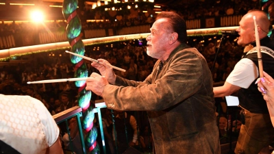 „Terminator“ Arnold Schwarzenegger dirigiert im Marstall-Festzelt. (Foto: Felix Hörhager/dpa)