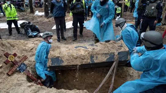 Ukrainische Rettungskräfte bergen bei der Exhumierung in Isjum einen Sarg. (Foto: Evgeniy Maloletka/AP/dpa)