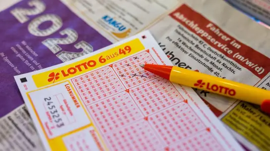 Ein Lottoschein und ein Kugelschreiber liegen in einer Annahmestelle auf dem Tresen. (Foto: Philipp von Ditfurth/dpa/Illustration)