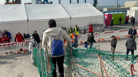 Nach tagelanger Überfahrt gehen gerettete Menschen von Bord der „Geo Barents“, die im Hafen von Ancona in Mittelitalien liegt. (Foto: -/MSF/dpa)