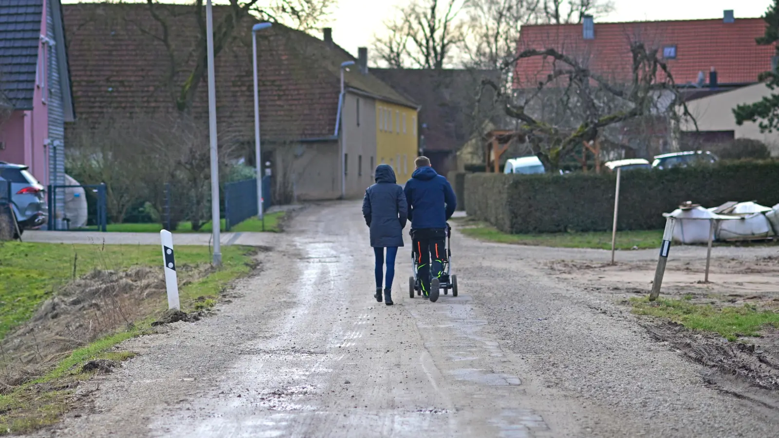 Ein junges Paar schiebt den Nachwuchs in Käferbach über die provisorisch befestigte Straße. Anwohner beklagen mangelnde Kommunikation der beteiligten Firmen und der Stadt. (Foto: Jim Albright)