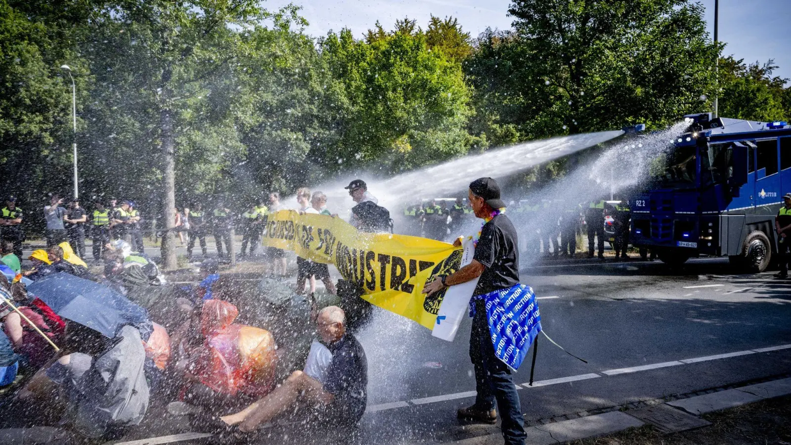 Einsatz von Wasserwerfern gegen Klimaaktivisten, die eine Straße blockieren. (Foto: Robin Utrecht/ANP/dpa)