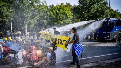 Einsatz von Wasserwerfern gegen Klimaaktivisten, die eine Straße blockieren. (Foto: Robin Utrecht/ANP/dpa)