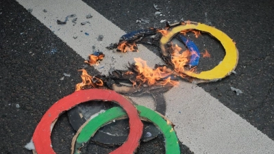 Mit brennenden Ringen machen einige Pariser am 1. Mai darauf aufmerksam, was sie wirklich von der Ausrichtung der Olympischen Spiele in ihrer Stadt halten. (Foto: Joao Daniel Pereira/ZUMA Press Wire/dpa)