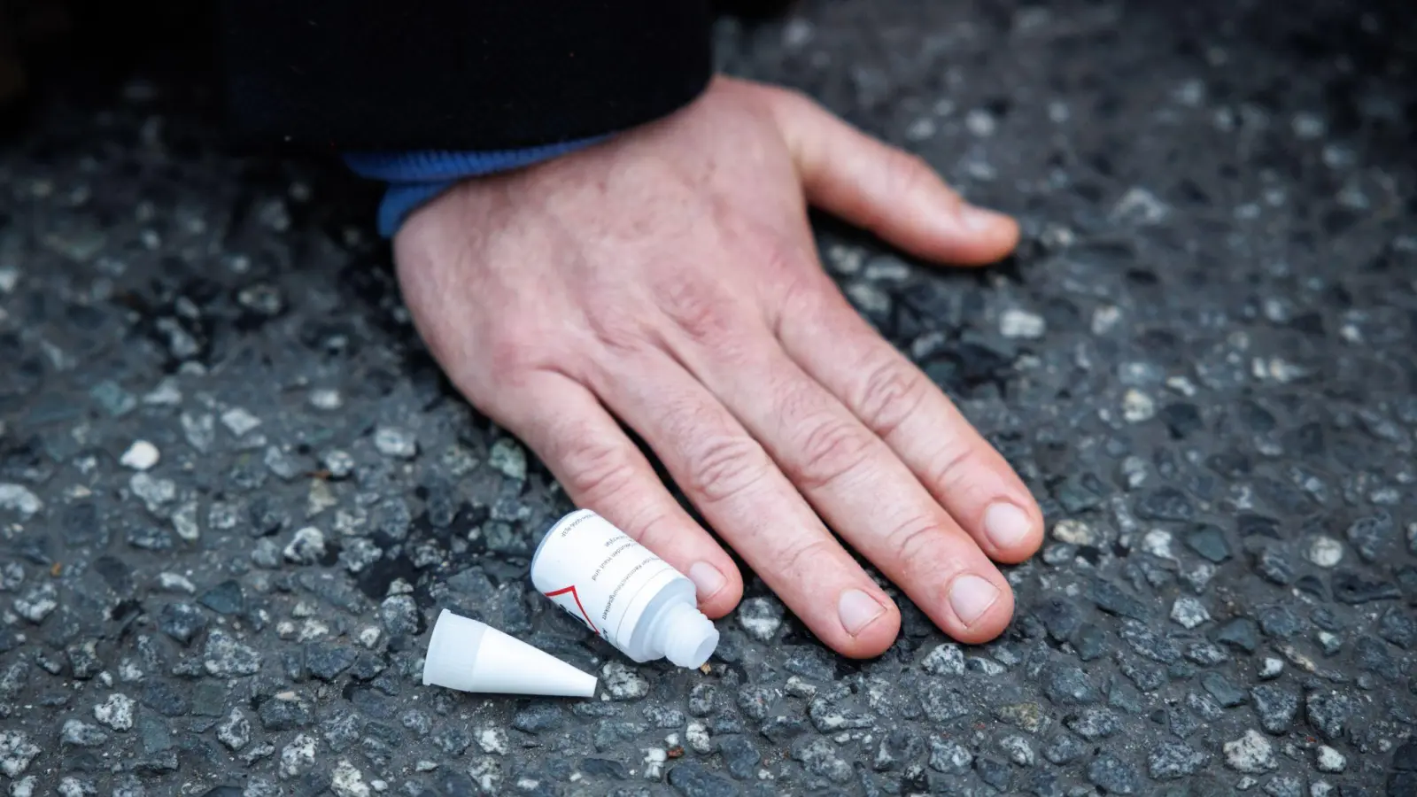 Ein Klimaaktivist ist mit der Hand auf einer Straße festgeklebt. (Foto: Matthias Balk/dpa/Symbolbild)