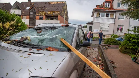 Eine Dachlatte steckt in der Windschutzscheibe eines parkenden Autos. Ein Unwetter hat auch in Paderborn große Schäden angerichtet. (Foto: Lino Mirgeler/dpa)