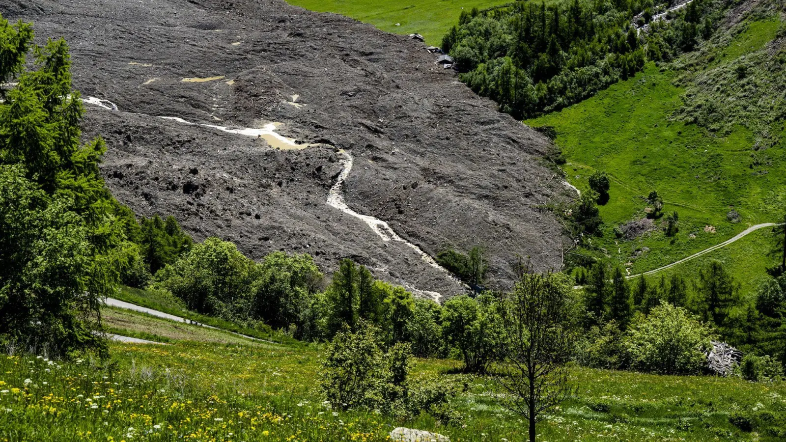 Der Fluss Lonza bahnt sich einen Weg durch den Schuttkegel. (Foto: Jean-Christophe Bott/KEYSTONE/dpa)
